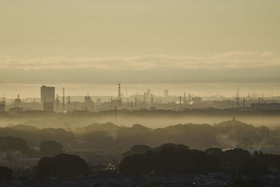 Silhouette cityscape against sky during sunset