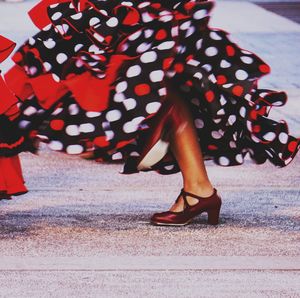 Low section of woman in red shoes