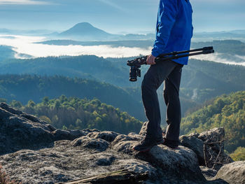 Nature photographer is checking camera screen to see if his shot was success. tourist takes photos