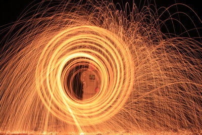 Man spinning wire wool at night