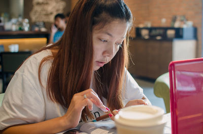 Close-up of woman sitting at table in cafe