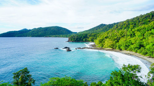 High angle view of sea and mountains against sky