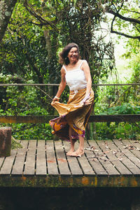 Portrait of woman standing against tree