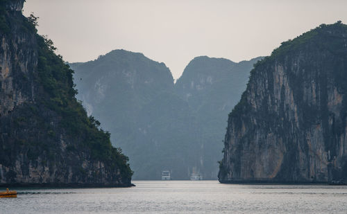 Scenic view of sea and mountains against clear sky