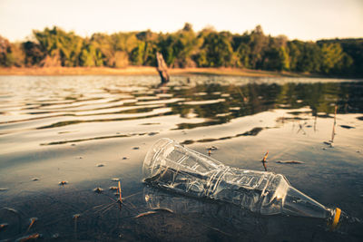 Garbage floating on lake against sky