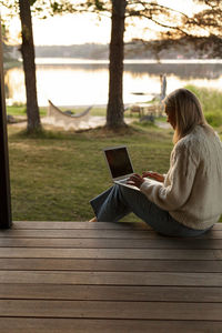 Woman using laptop on porch