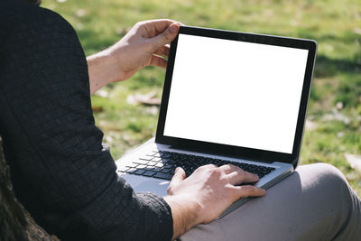 Midsection of man using laptop