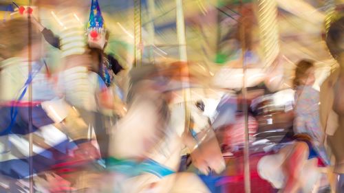 Blurred motion of people at carousel