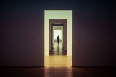 Rear view of woman standing in corridor 