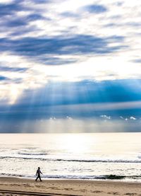 People looking at sea against sky
