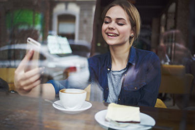 Young woman holding coffee cup at cafe