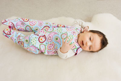 High angle view of cute baby girl sleeping on bed