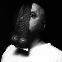 Close-up of man looking away against black background