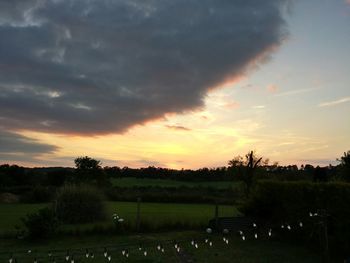 Scenic view of field against cloudy sky