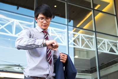 Businessman checking time outside office building