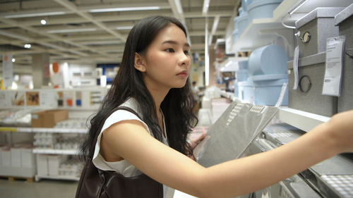 Woman looking while standing by basket