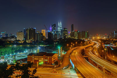 Distant view of petronas towers against sky in illuminated city at night