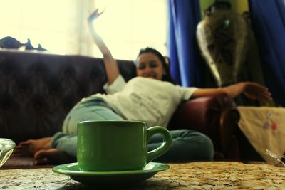 Midsection of woman with coffee at home