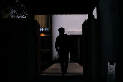 Rear view of silhouette man standing in building