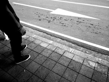 Low section of man walking on road