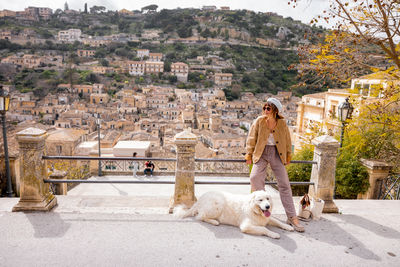 Rear view of woman with dog sitting on table