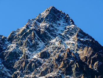 Low angle view of snowcapped mountain against clear blue sky, monviso, italy 