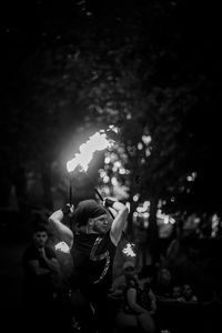 People holding illuminated flower at night