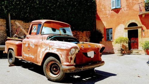 Old car on street against buildings in city