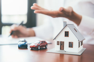 Close-up of hand holding toy on table in building