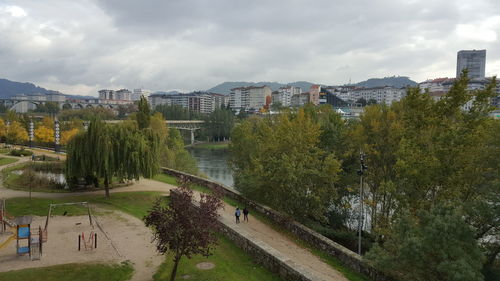 Panoramic view of trees and city against sky
