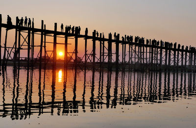 Silhouette pier on sea against sky during sunset