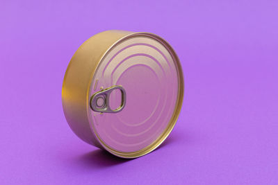 Unopened tin can with blank edge on violet background