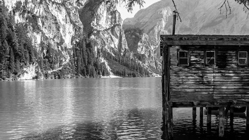 Stilt house by lake against mountain