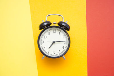 Close-up of alarm clock on colored background 