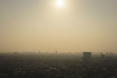 Buildings in city against clear sky during sunset