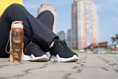 Low section of man relaxing in city