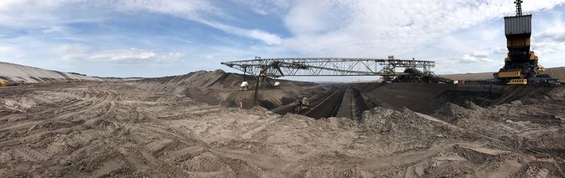 Panoramic shot of machinery on field against sky