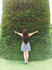 Rear view of woman standing against plants