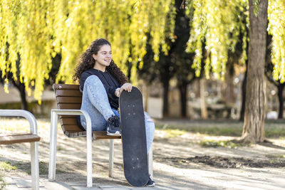 Woman sitting on bench in park