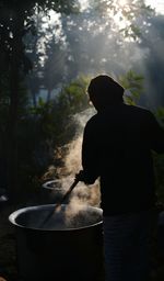 Man preparing food standing amidst trees