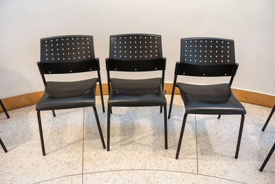 Empty chairs against wall