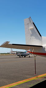 Airplane on airport runway against clear blue sky