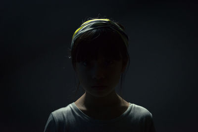 Close-up portrait of boy against black background