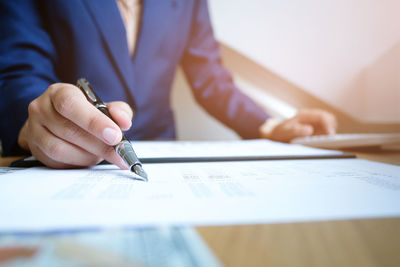 Close-up of businessman writing in paper