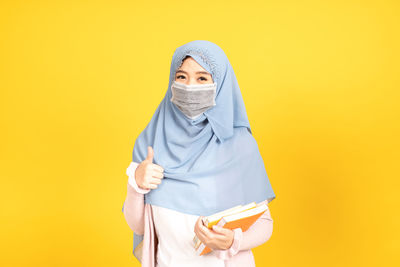 Portrait of mid adult man against yellow background