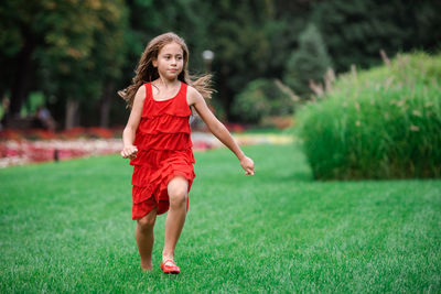 Portrait of a woman running on grass