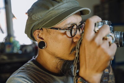 Man repairing camera at workplace