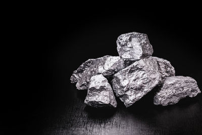 Close-up of ice cream on rock against black background