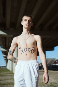 Portrait of young man standing against wall