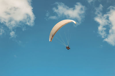 Low angle view of paragliding against sky